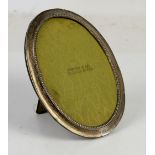 Large velvet backed oval silver photo frame with beaded inner edge, 24 cm high, retailed by Simons &