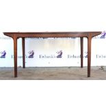 Modern rosewood extending dining table on tapered supports with four extra leaves bearing label