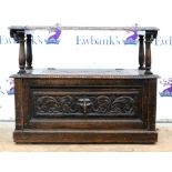 Stained oak monks bench with lion mask decoration and column supports. 91W x 74H x 46D