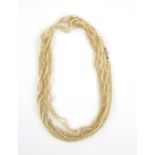 Early 20th C rope length seed pearls necklace comprising of four twisted rows, clasp testing as 14