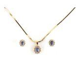 Sapphire and diamond cluster pendant and earring set, the pendant is set with a central oval cut