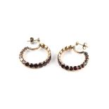 Pair of Georgian garnet hoop earrings, each set with eighteen round cut garnets to the full hoop,