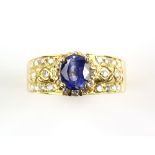 Modern sapphire and diamond ring, oval sapphire, weighing an estimated 1.24 carats, surrounded by