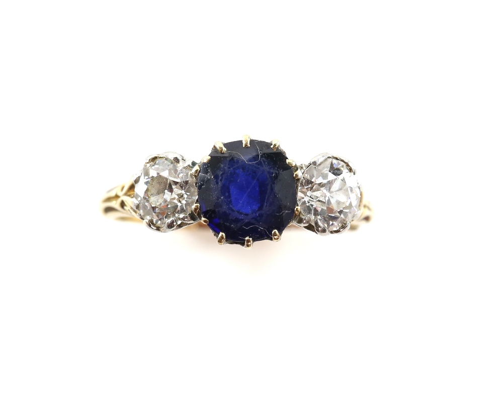 Sapphire and diamond three stone ring, centrally set with a round cut sapphire, estimated weight 1.