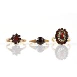 Three garnet set rings, one single stone with ornately decorated shoulders, size P and two cluster