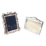 Two modern silver-mounted photograph frames including a landscape frame decorated in swags and bows,