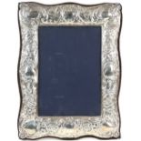 Modern silver-mounted frame, chased with scrolls and vacant cartouche, with velvet back and stand,