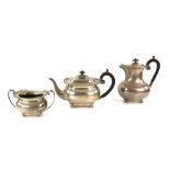 George V silver presentation three piece part tea service, comprising teapot, hot water jug and