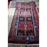 Kazak rug with three medallions and bird, animal and geometric motifs on a black ground, within