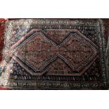 Persian Qashqai rug, double pole medallion and stylised floral and animal motifs on a red ground
