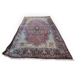 AMENDED DESCRIPTION Large Persian Kirman carpet, with a central floral medallion with scrolling