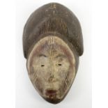 Punu dance mask, Gabon, wood carved, traces of kaolin pigment, the face round and features petite,