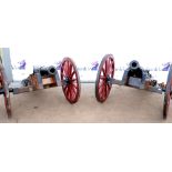 Pair of 19th century cannons, the barrels on carriages with metal bound spoked wheels, bearing