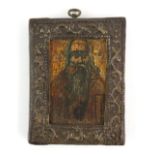 18th/19th century icon depicting a saint with long beard, on wooden panel in embossed metal mount,