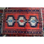 Kazakh style red ground rug with three medallions within stylised floral borders, 154 x 104cm