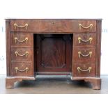Late 19th/20th century serpentine mahogany and crossbanded kneehole desk, with one long secretarie
