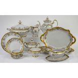 Weimar porcelain dinner service for 12, decorated in gilt with a band of scrolling leaves and