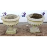 Pair of composite stone garden planters of urn form, with egg and dart decoration to rim above