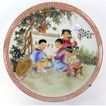 A Chinese famille rose circular dish, decorated with a scene of four children in a garden classroom;