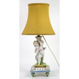 Porcelain figural lamp with putto holding cornucopia, on square base with four feet, anchor mark