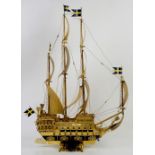 Cast metal and enamel model of a Swedish galleon, on scrolling foliate base with the lesser arms