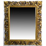 19th century giltwood wall mirror with rococo foliate frame. 102H x 84W