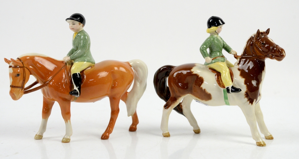 Pair of Beswick figures, a skewbald pony with girl rider and a Palomino with boy rider, each