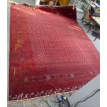 Large red ground Afghan carpet, repeating gul motifs on a red ground, contained within repeating
