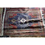 Kazak rug with three medallion and bird and animal motifs on a blue ground, within stylised floral