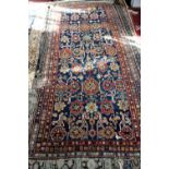 Persian blue ground rug with repeating floral motifs on a dark blue ground contained within multi