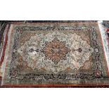 Persian part silk rug, signed, with a central floral medallion and floral motifs on a cream ground