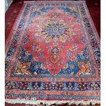 Persian rug with central floral medallion and floral motifs on a pink ground, within floral
