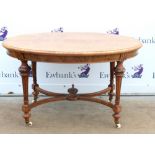 Late 19th century burr walnut oval dining table on turned and reeded legs united by an X-stretcher