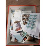 A BOX OF ASSORTED STAMPS FROM AROUND THE WORLD AND FIRST DAY COVERS