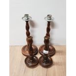 A PAIR OF OAK BARLEY TWIST CANDLESTICKS TOGETHER WITH A PAIR OF OAK CANDLESTICKS