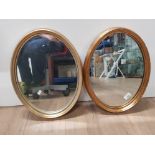 A PAIR OF GILT FRAMED OVAL SHAPED MIRRORS