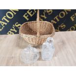 A WICKER BASKET CONTAINING A CUT CRYSTAL DECANTER AND A COMMEMORATIVE GLASS BASKET