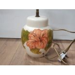 A MOORECROFT HIBISCUS PATTERNED TABLE LAMP ON A CREAM BACKGROUND 20CM X 15.5CM