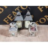 A PAIR OF CHROME CANDLE LANTERNS TOGETHER WITH A PAIR OF BATTERY POWERED CANDLE LANTERNS