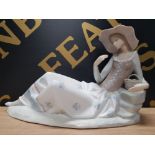 LLADRO FIGURE OF A LADY LYING DOWN WITH A BASKET OF FLOWERS SAS