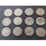 12 GEORGE V ONE FLORIN COINS ALL PRE DATE 1947 IN PROTECTIVE SLEEVE