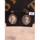 A PAIR OF ANTIQUE MINIATURE PHOTO FRAMES WITH OVAL OPENINGS OF GILDED METAL AND ACORN SWAG