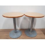 A PAIR OF BEECH CIRCULAR TOPPED TABLES ON SOLID METAL BASE
