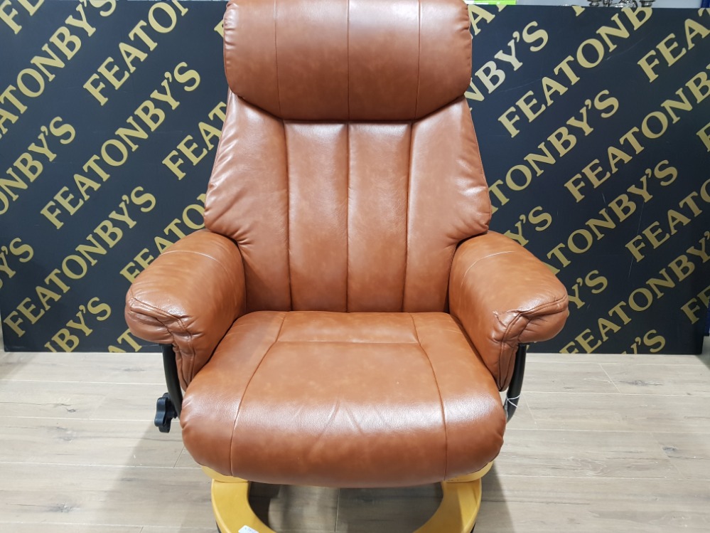 A STRESSLESS STYLE SWIVEL ARM CHAIR AND FOOTSTOOL WITH STORAGE COMPARTMENT