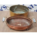 A LARGE TWIN HANDLED BRASS PAN TOGETHER WITH A COPPER PAN RAISED ON FOUR LEGS WITH TWIN HANDLE
