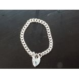 A SILVER CURBLINK BRACELET WITH HEART SHAPED PADLOCK CLASP