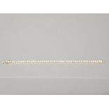 A CUBIC ZIRCONIA AND GOLD COLOURED METAL SET TENNIS BRACELET 19CM LONG