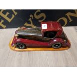 A HAND CARVED ABS PAINTED MODEL OF CAR ON PLINTH