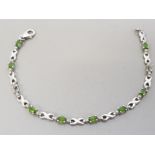 SILVER AND PERIDOT LINE BRACELET, 2 STONES MISSING