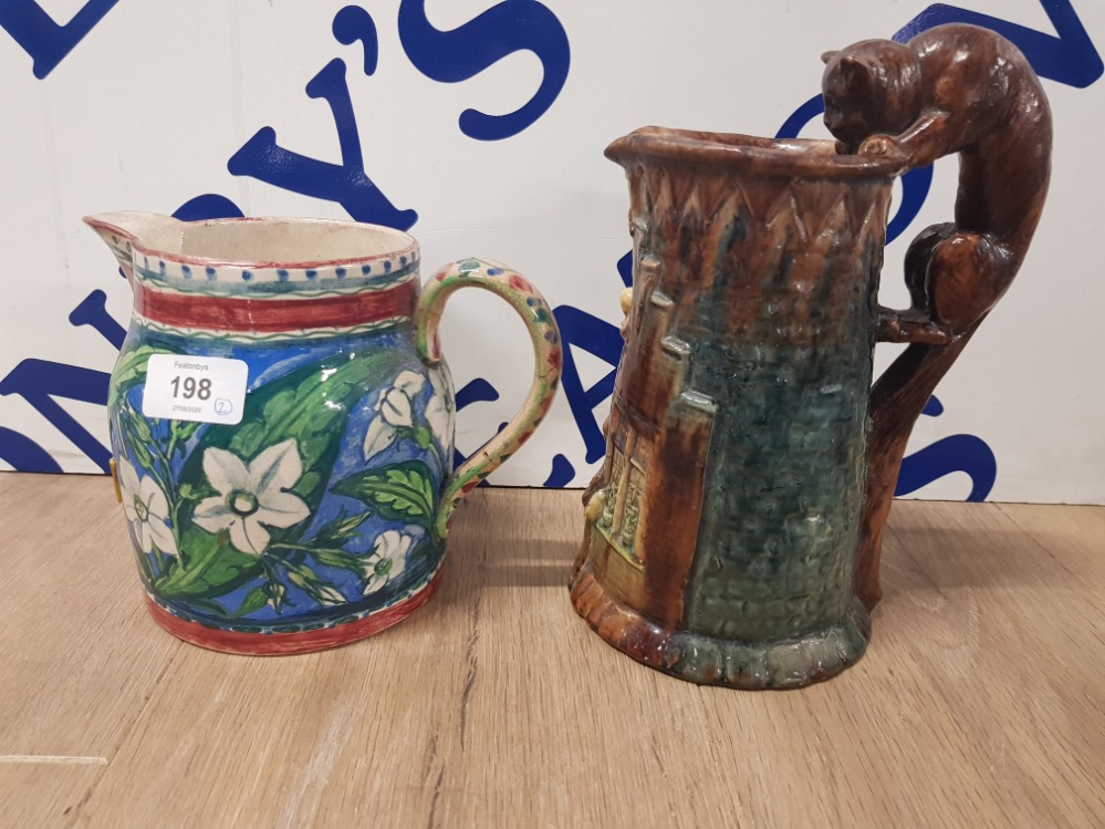 A HAND PAINTED STUDIO POTTERY JUG SIGNED EGJ TOGETHER WITH ANOTHER WITH CAT PATTERN HANDLE